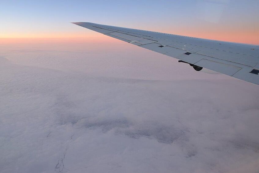 Sunset over the Southern Ocean between New Zealand and Antarctica. Pack ice is visible below the cloud layer.